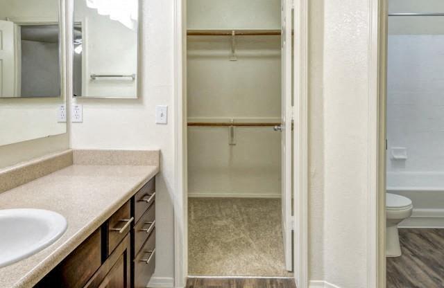 Ingleside Apartments Bathroom  with brown cabinets, beige counter tops and large walk in closet