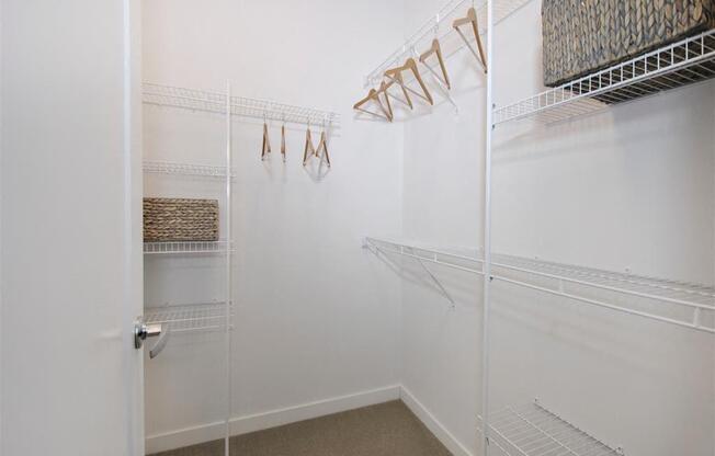 a walk in closet with white walls and a white door