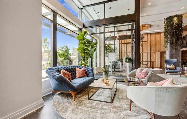 a living room with a blue couch and a large window at Coda at Bryant Street, Washington