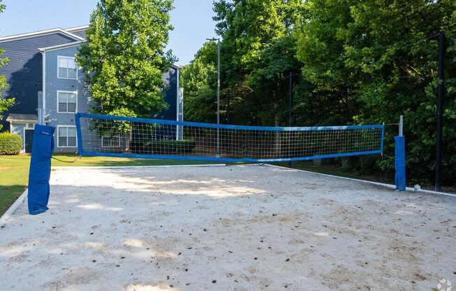 a tennis court with a blue net in front of a house