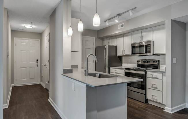 A modern kitchen with a large island and stainless steel appliances.