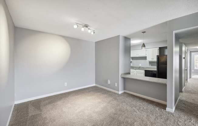 the living room and kitchen of an apartment with gray walls and carpet  at Governors House, Huntsville