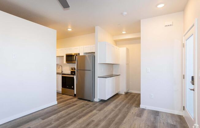 an entry way with wood floor and refrigerator at Palisade Park Townhomes, Broomfield