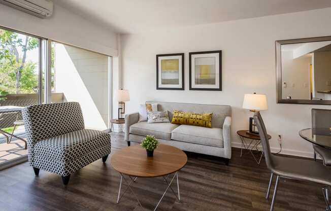 Two Bedroom Apartments in Palo Alto, CA - Palo Alto Place - Furnished Living Room with Wood-Style Flooring and Sliding Glass Door to Patio.