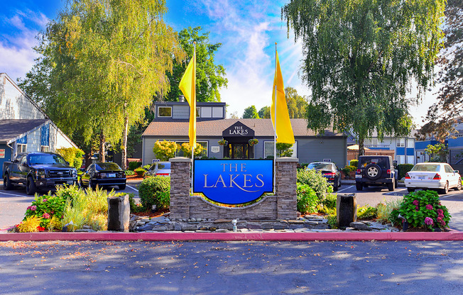 a sign for the lakes in front of a parking lot