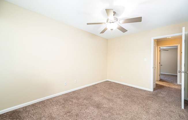 a room with carpet and a ceiling fan