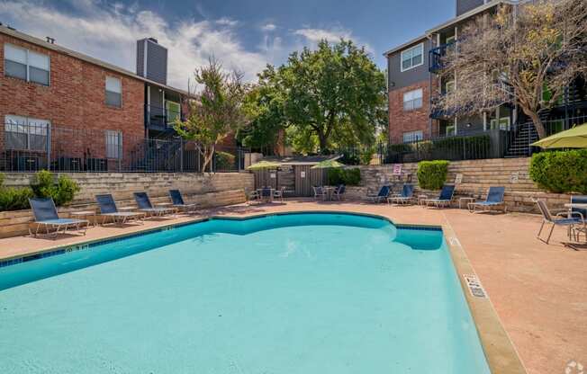 our apartments have a swimming pool with chairs and umbrellas