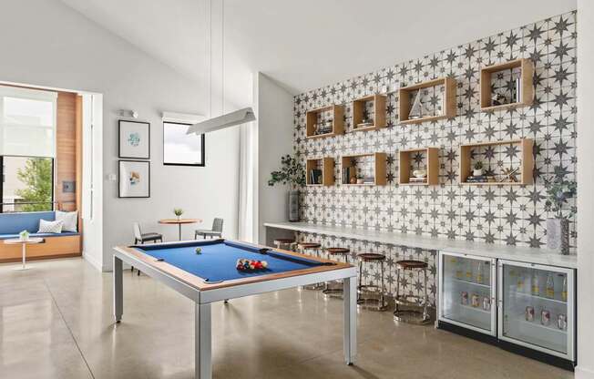 A pool table in a room with a wallpapered wall.