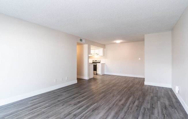 A room with wooden flooring and white walls.