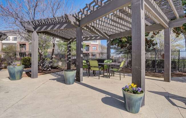 a patio with a pergola and tables and chairs