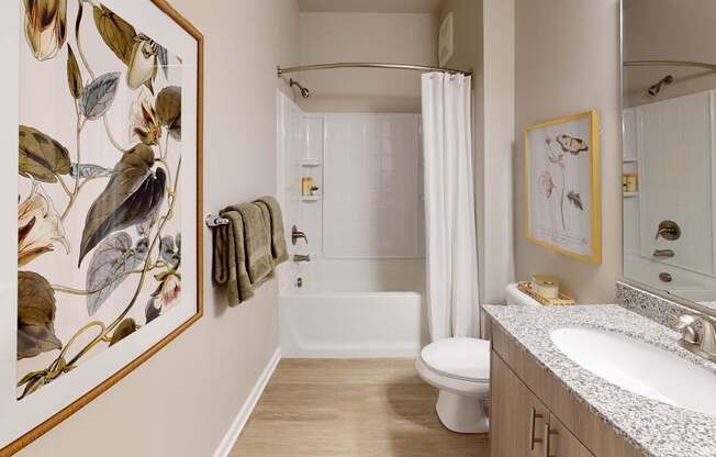 a bathroom with granite countertops and vanity lighting