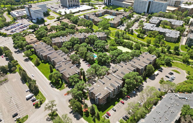 A bird's eye view of a residential area with multiple buildings and cars.