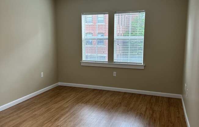 an empty room with a window and a wooden wall