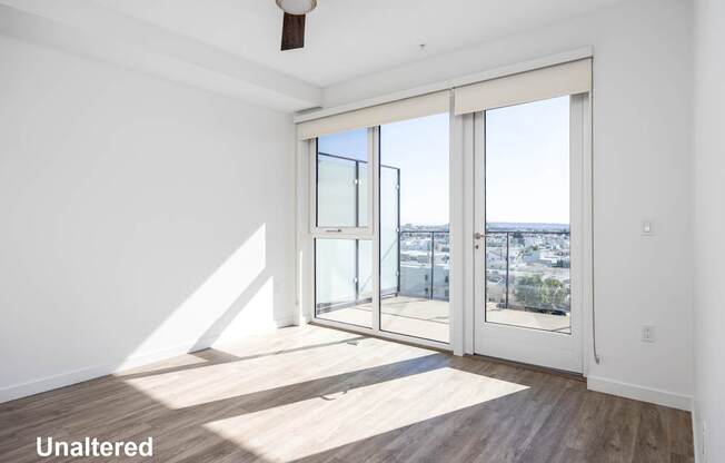 A room with a sliding glass door leading to a balcony.