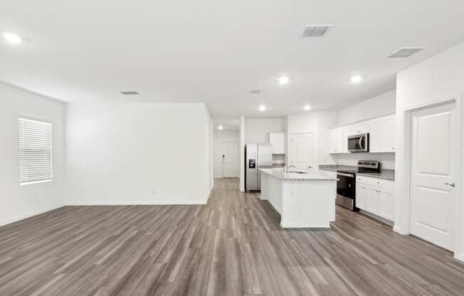 a living area with white walls and hardwood floors