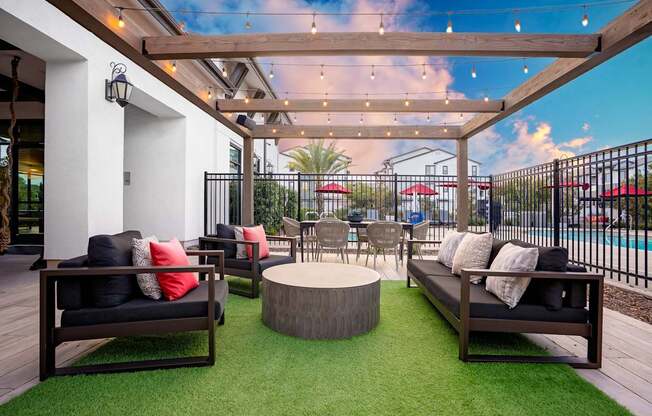 A patio with a black couch and a wooden table.