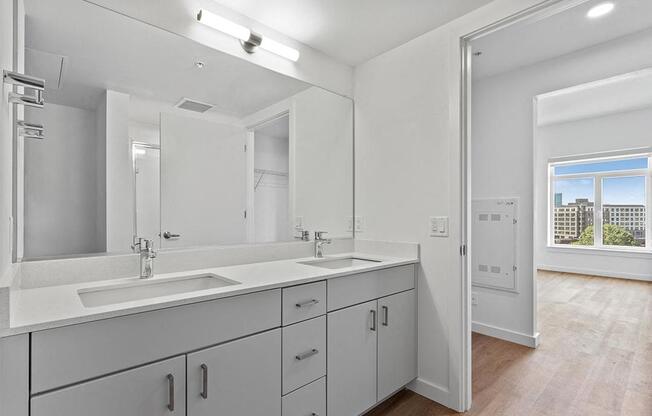 a bathroom with two sinks and a large mirror