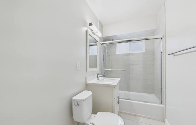 A white toilet sits next to a sink in a small bathroom.