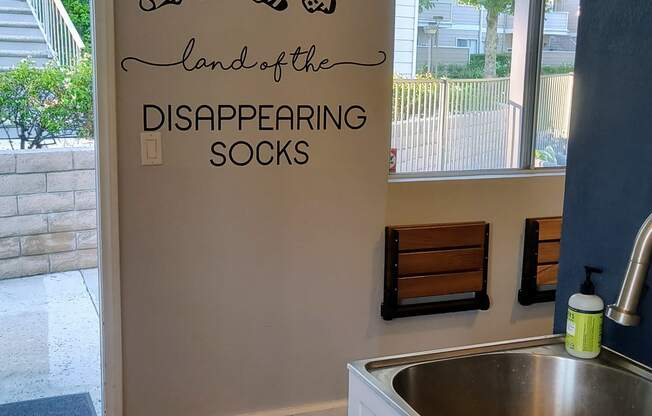 a kitchen with a sink and a wall that says laundry room land of the disappearing socks