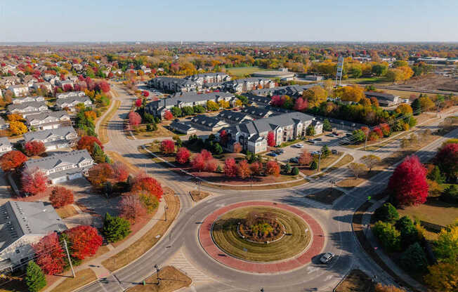 A roundabout in a suburban area with trees showing autumn colors.