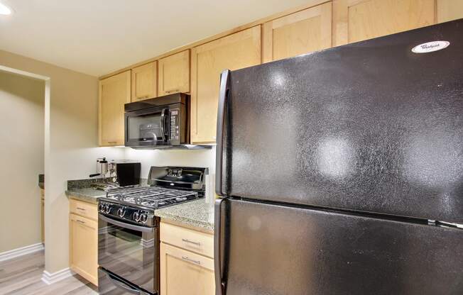 the kitchen has stainless steel appliances and wood cabinets