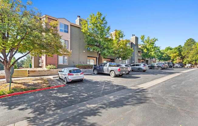 A parking lot with cars and apartment buildings in the background.
