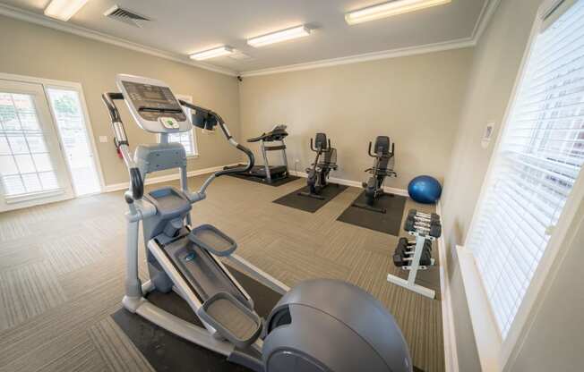 a gym with cardio equipment and weights at the belgard apartments