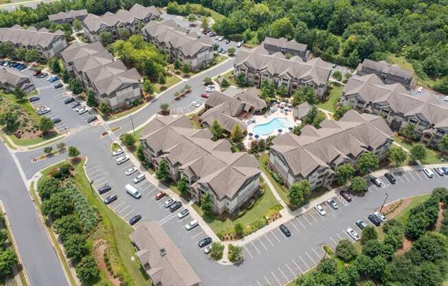 an aerial view of a subdivision of houses with a swimming pool in the middle of the road