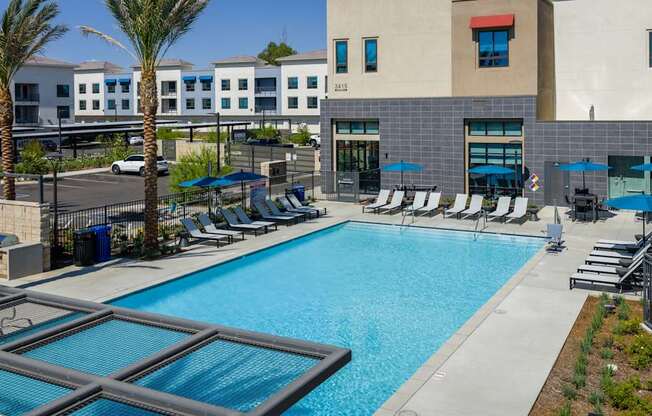 A swimming pool with a glass divider and lounge chairs.