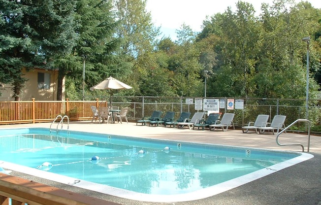 a resort style pool with chairs and an umbrella