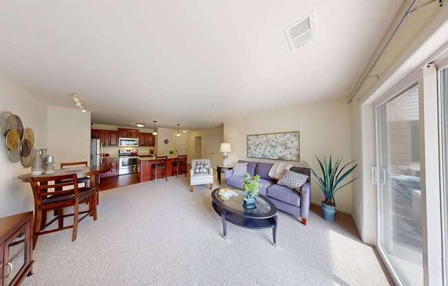 A living room with a couch, coffee table, and a dining table.