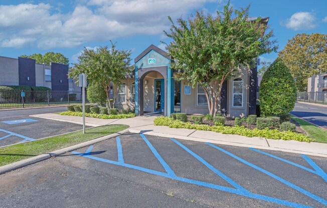 A blue and white leasing office with disabled parking spots at The Drake in Bossier City, LA