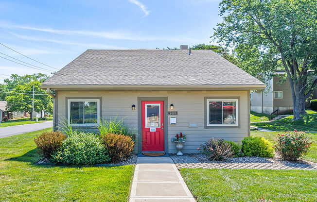 the front of a small house with a red door