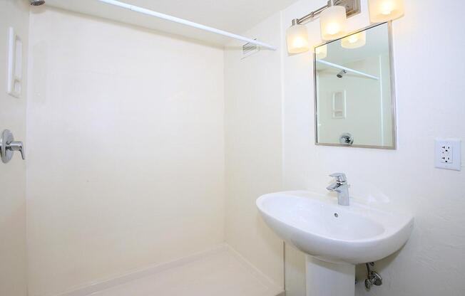 a white sink sitting under a mirror