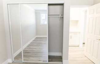 an empty hallway with a stainless steel refrigerator in a closet