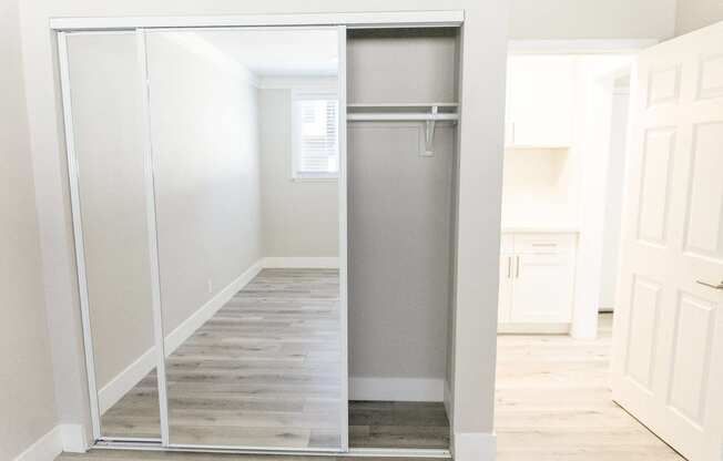 an empty hallway with a stainless steel refrigerator in a closet