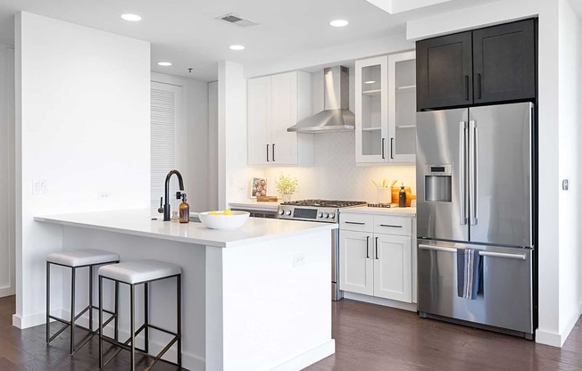 A modern kitchen with a white island and stainless steel appliances.