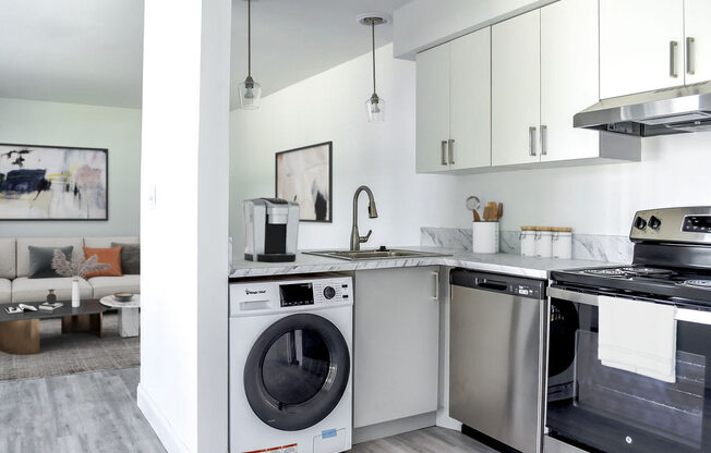 a white kitchen with stainless steel appliances and white cabinets