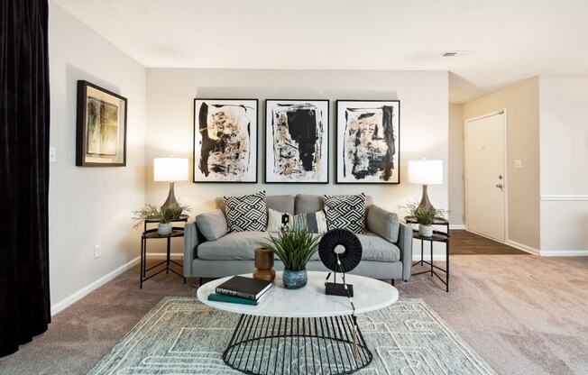 a living room with a grey couch and a white coffee table