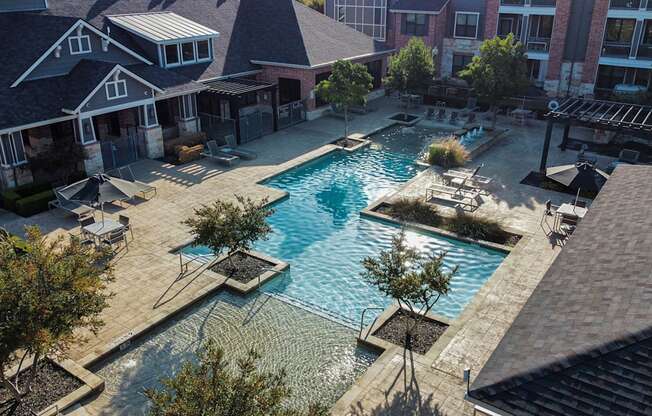 an aerial view of a swimming pool in front of a house