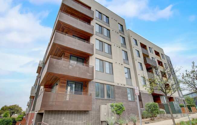 an apartment building with two balconies and a blue sky