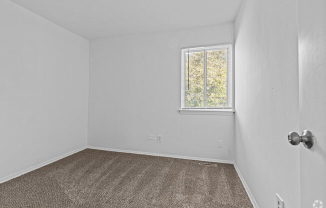 an empty room with carpet and a window