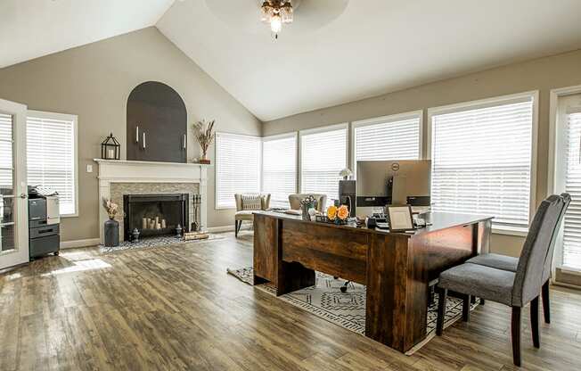 a living room with a fireplace and a desk with a computer