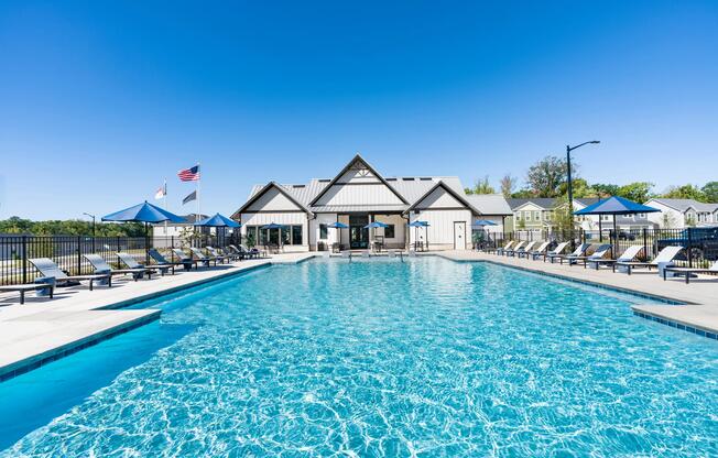 The resort-style pool features expansive swimming space, comfortable poolside lounge seating, shaded relaxation areas, and direct access to the resident clubhouse, creating a central destination for outdoor recreation and relaxation.