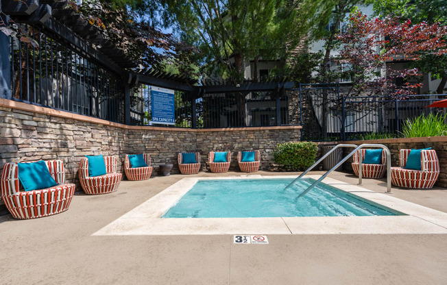 a swimming pool with chairs and a building in the background