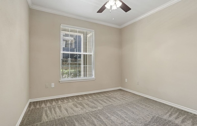 Edinburgh bedroom with a ceiling fan and a window at Encore at Buckingham Apartments in Richardson, TX