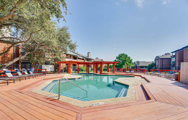 a swimming pool with a wooden deck with chairs around it