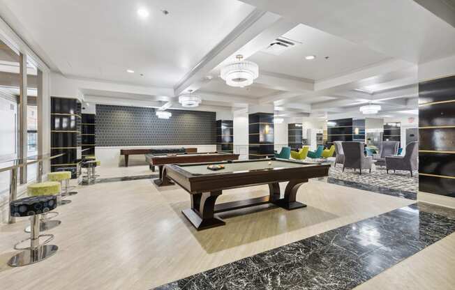 a spacious game room with two pool tables and a bar