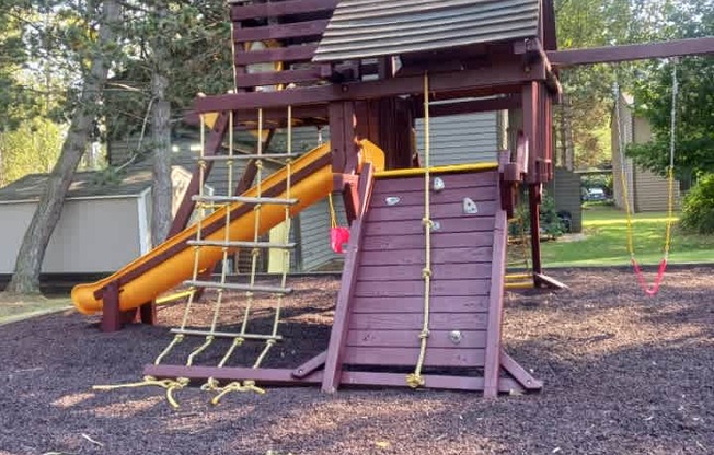A playground with a slide and a wooden structure.