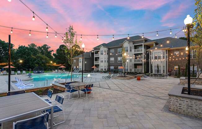 Saltwater pool with outdoor entertaining areas with bistro string lights during sunset